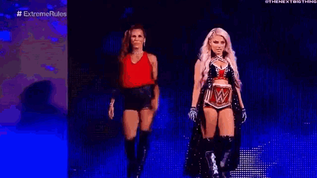 two female wrestlers are walking on a stage .