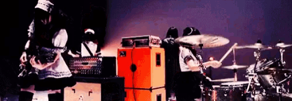 a person playing a guitar in front of an orange amplifier that says orange
