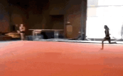 a girl is doing a trick on a red mat