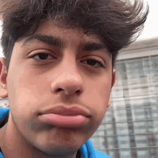 a young man is making a funny face with his mouth open .