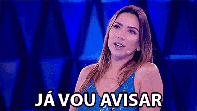 a woman in a blue dress is standing in front of a microphone with the words ja vou avisar above her