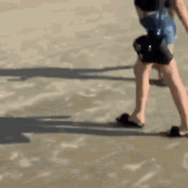 a woman in a bikini is walking on the beach .