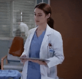 a female doctor in a lab coat holds a tablet