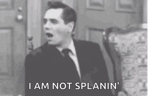 a man in a suit and tie is sitting in a chair and saying `` i am not splanin '' .