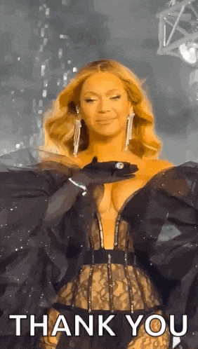 a woman in a very revealing dress is standing on a stage and saying `` thank you '' .