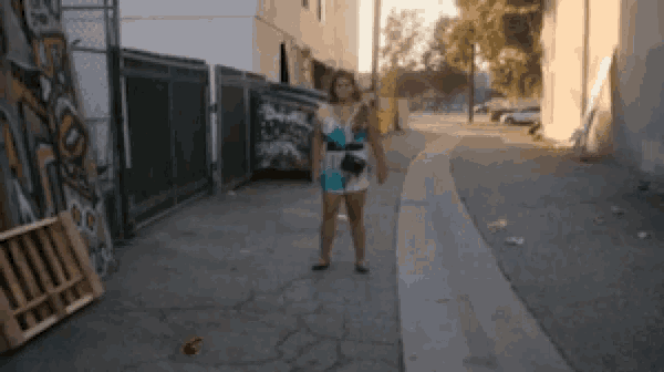 a woman in a blue and white dress is walking down a sidewalk