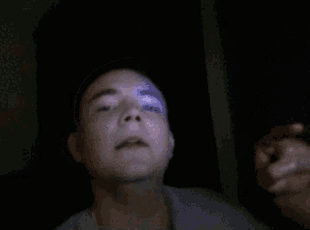 a man 's face is shown in a blurry photo with a blue light behind him