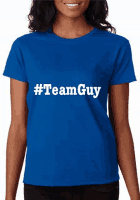a woman wearing a blue shirt that says #team guy