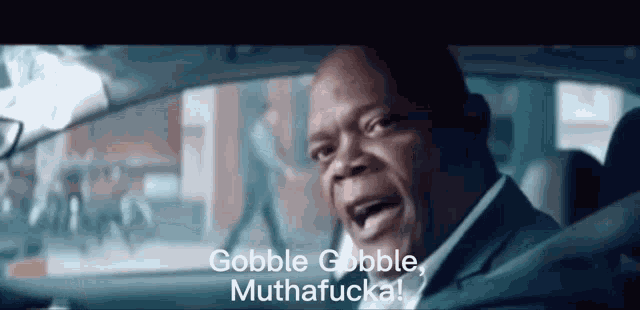 a man in a car with the words gobble gobble muthafucka on the screen
