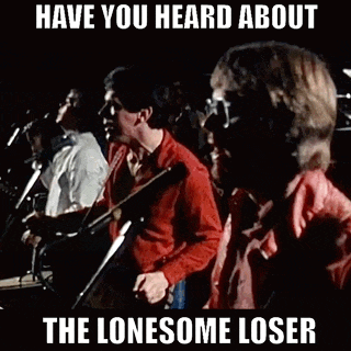 a group of men are standing in front of microphones and singing into them .