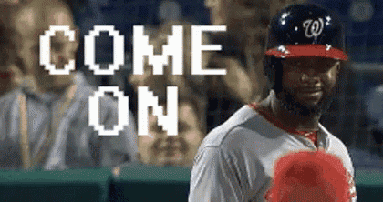 a baseball player is standing in the outfield with the words `` come on '' written on the screen behind him .