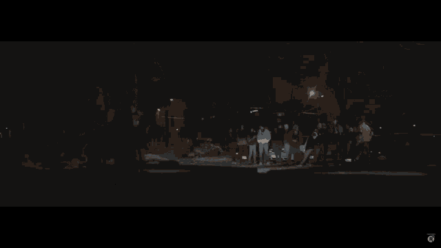 a group of people standing around a car at night