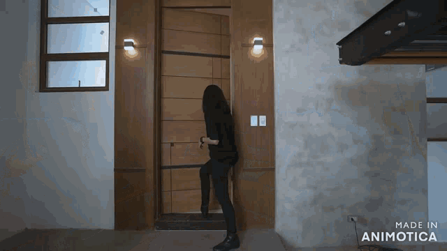 a woman is standing in front of a door that says made in animotica on the bottom