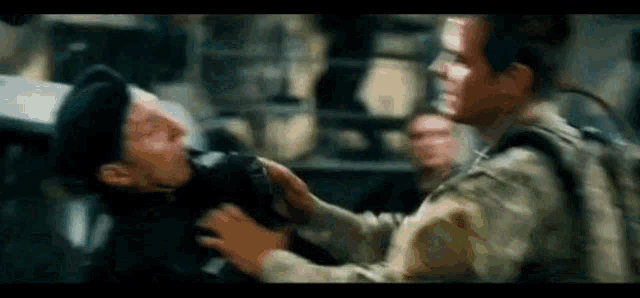 a man in a military uniform is holding another man 's hand .