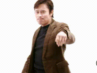 a man in a suit is pointing at the camera with a starburst in the background .