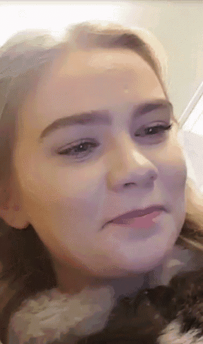 a close up of a girl 's face with a purple background
