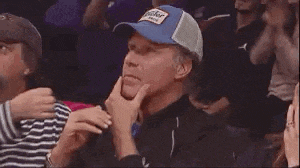 a man wearing a blue hat is sitting in a stadium .