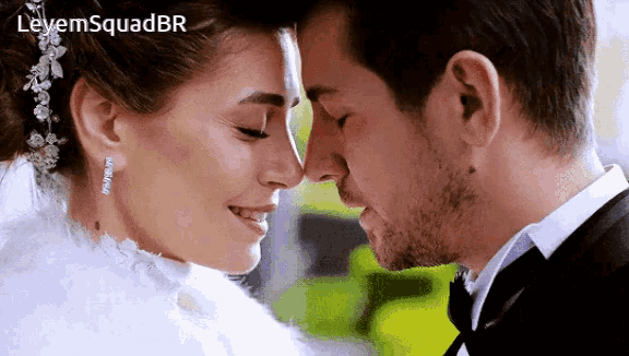 a close up of a bride and groom touching their noses with the letters leyem squadbr above them