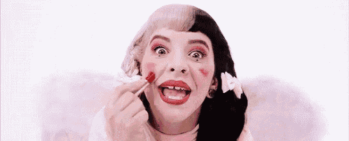 a woman with a tooth missing is applying red lipstick to her lips .