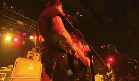 a man playing a guitar in front of a sign that says frc