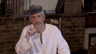 a man wearing a white shirt and a blue hat has a ring in his finger