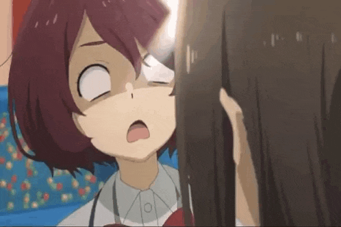 a girl with red hair is making a funny face while looking at another girl 's face .