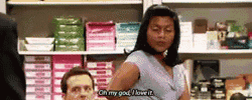 a man and a woman are sitting in a store and the woman is saying oh my god i love it .