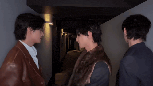 three young men are standing in a hallway and one of them is wearing a fur vest