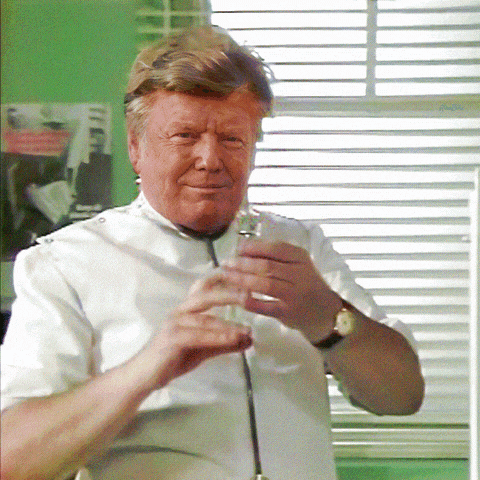 a man with a stethoscope around his neck is holding a glass in his hand