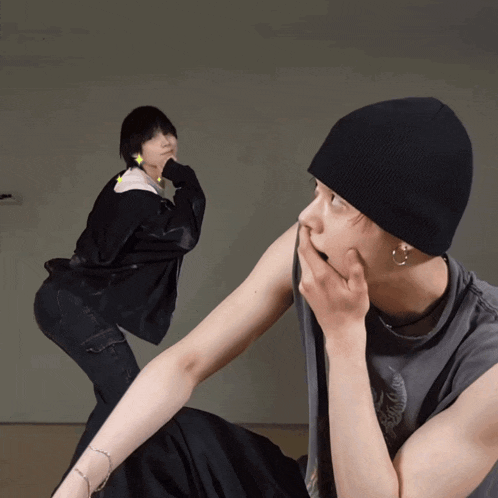 a man in a black beanie looks at another man