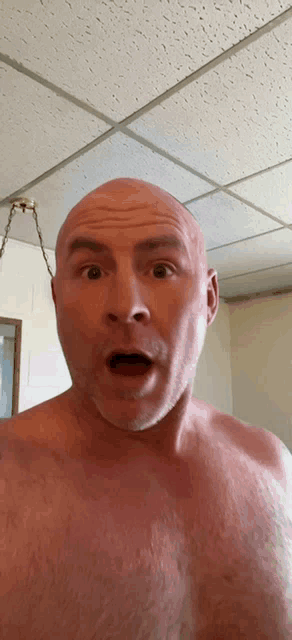 a man without a shirt is making a surprised face with his mouth open