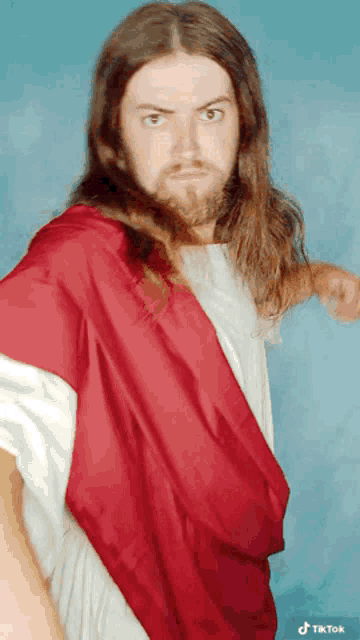 a man with long hair and a beard is wearing a red robe and a white shirt