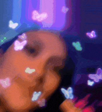 a close up of a person 's face with butterflies flying around
