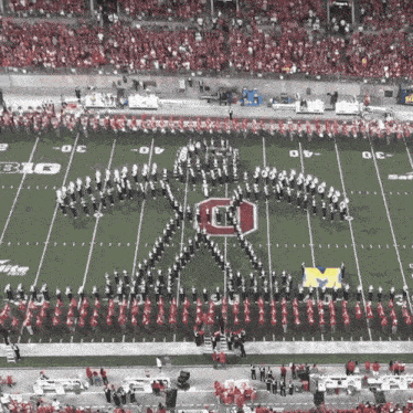 a marching band performs on a football field with the letter o on it