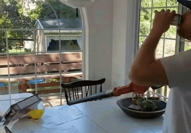 a man is drinking from a bottle while sitting at a table