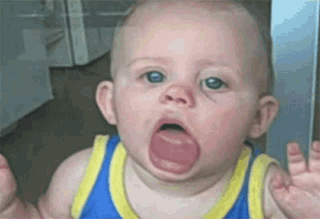 a baby is making a funny face with his tongue out