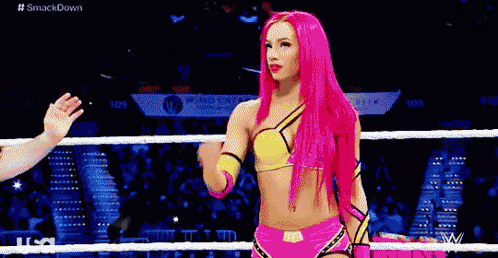 a woman with pink hair is standing in a ring .
