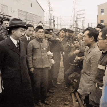 a group of men are standing around a man in a hat