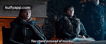 two men are sitting at a table and one of them is saying you stand accused of murder