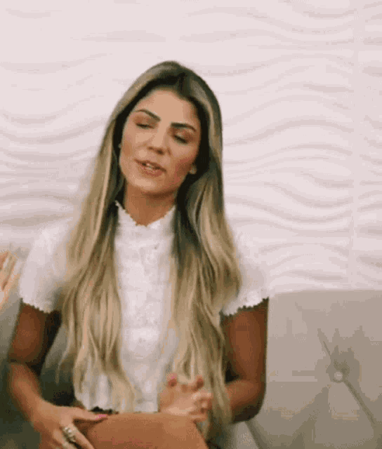 a woman in a white shirt is sitting on a couch