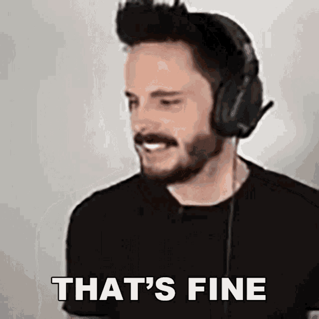 a man with a beard is wearing headphones and making a face .