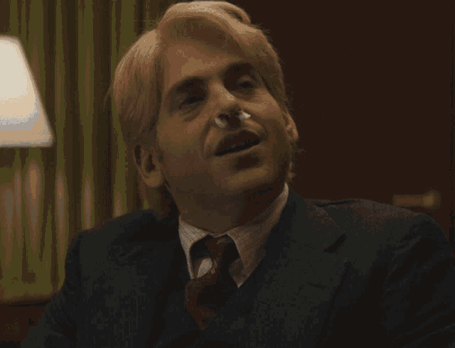 a man in a suit and tie says " all of this makes me tremendous "