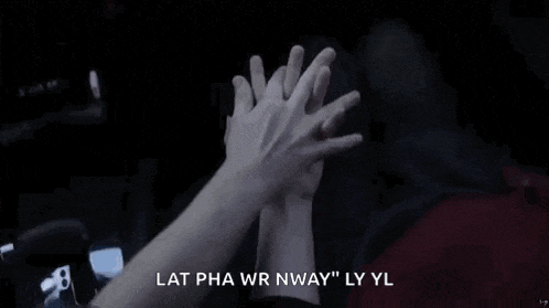 a couple of people are giving each other a high five .