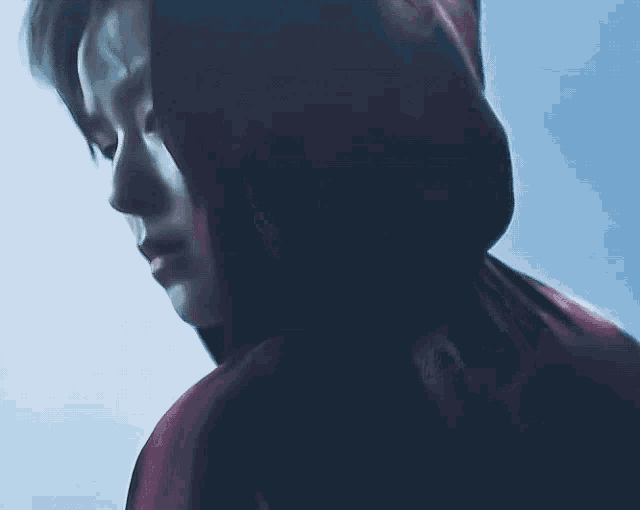 a close up of a person wearing a red hooded jacket