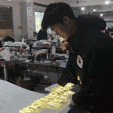 a man in a black jacket is working on a sign that says it 's ok