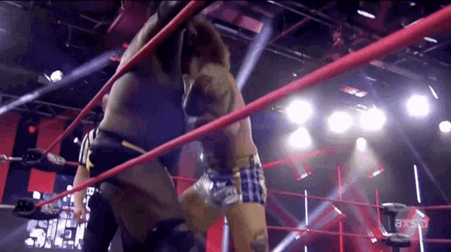 two wrestlers are wrestling in a ring with a sign that says axstv on it