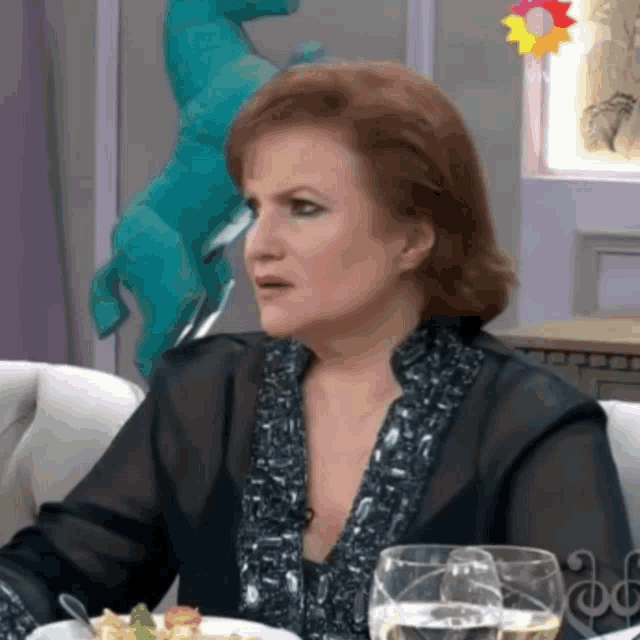 a woman sitting at a table with two glasses of water
