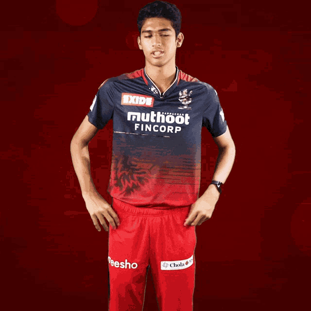 a man wearing a red and blue shirt that says exide muthoot fincorp