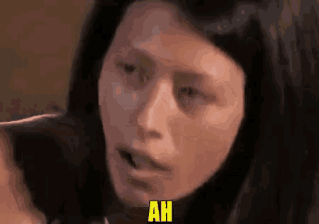 a close up of a woman 's face with the word ah written in yellow .