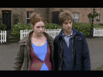 a man and a woman standing next to each other on a street